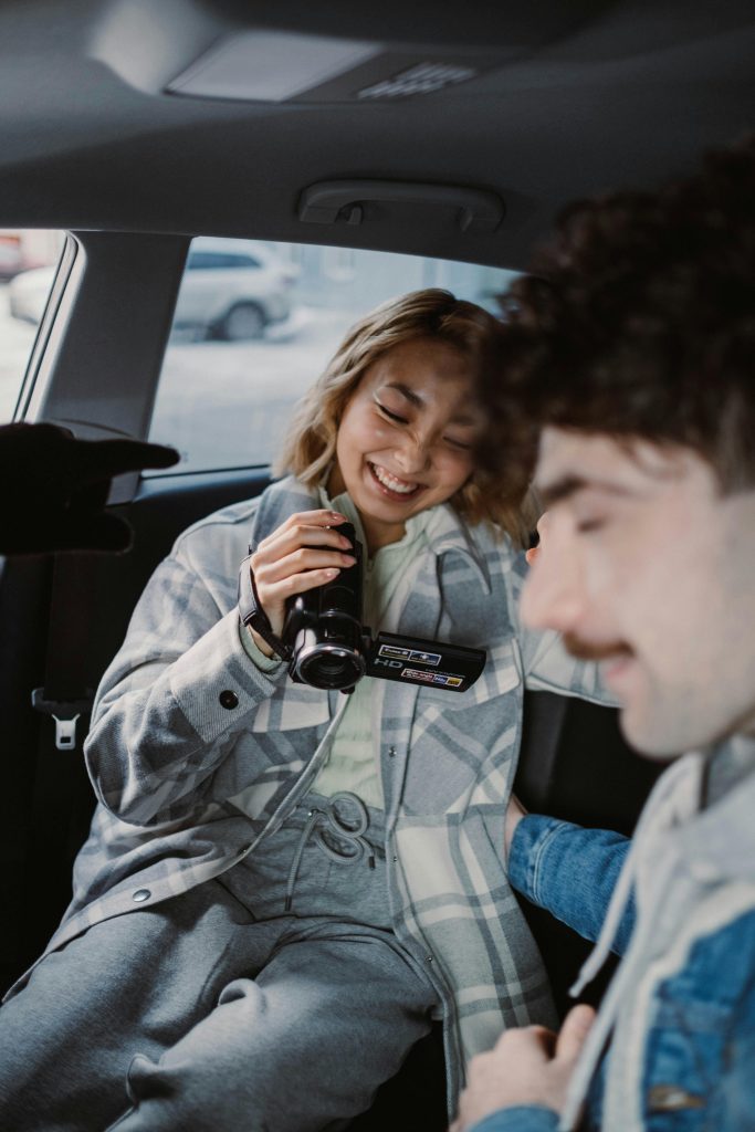 Woman in Gray Jacket Holding Black Dslr Camera